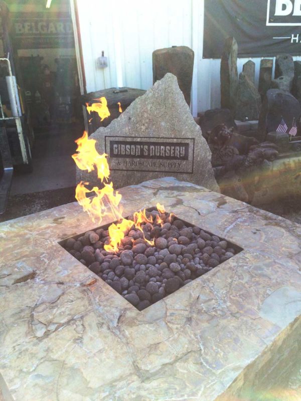 large fabricated stone fire pit with square hpc insert and lava stones