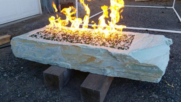 large, long natural stone with custom fabricated insert for fire insert on top and rock with flames coming out