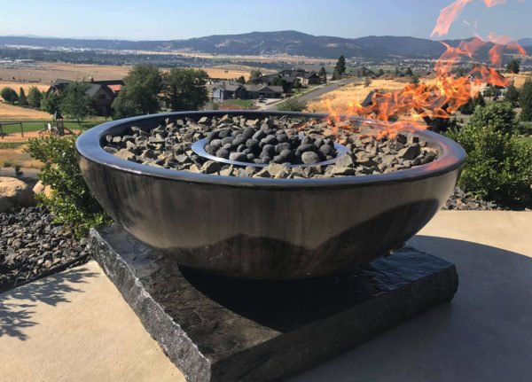 bowl fire pit with basalt rock chips overlooking large property with a view of the mountains