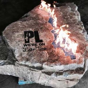 Engraved fire rock that reads PL We're on Lake Time
