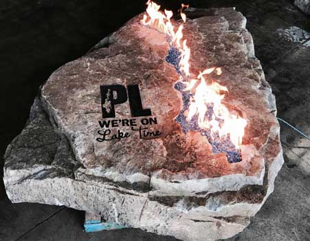 Engraved fire rock that reads PL We're on Lake Time
